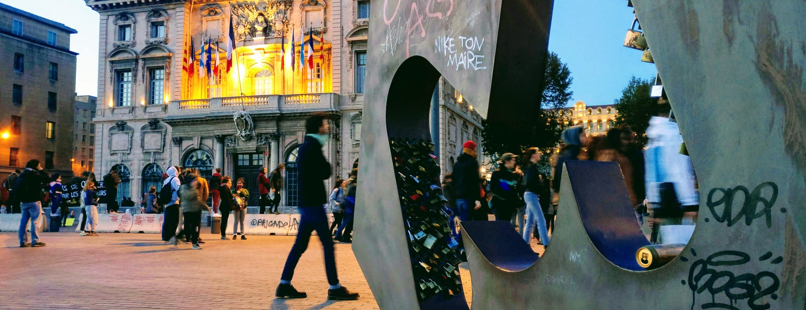 mairie de marseille avec des barrière et un superbe nik ton maire sur la statue du "M" de Marseille